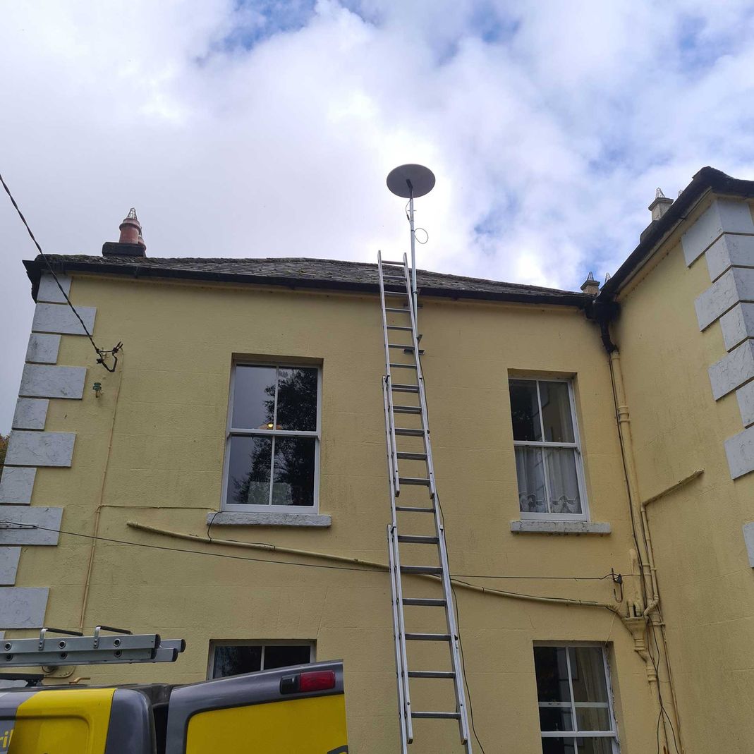 starlink antenna being installed on a two-storey house